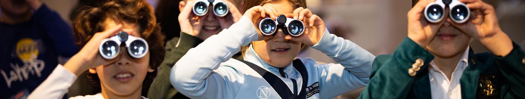 Schoolklas met verrekijkers in het museum